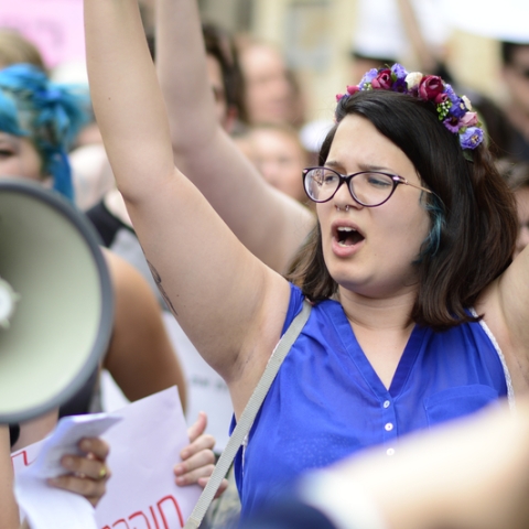 Female protester raising her arms during a march