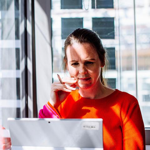 Woman in red jumper working at desk