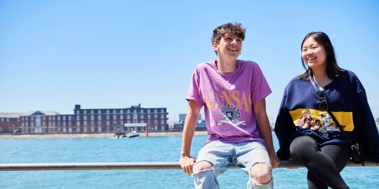 Two students sitting on the railing overlooking Gosport