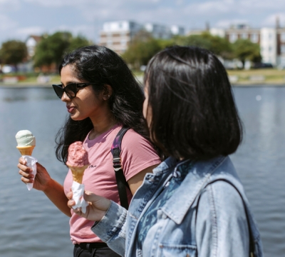 Two female students walking eating ice cream