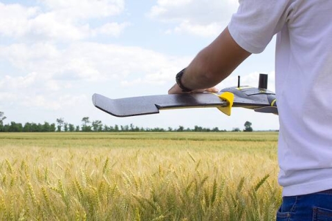 Man holding drone in a field