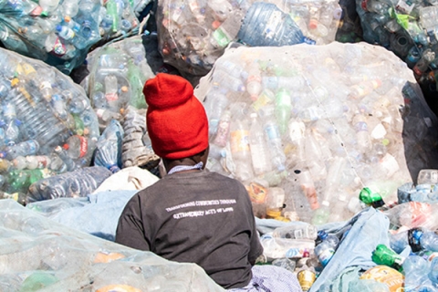 A person sorting plastic waste © James Wakibia
