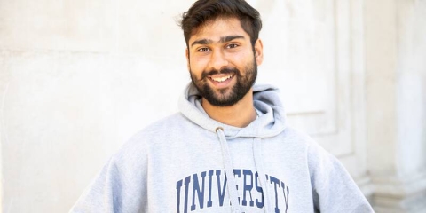 male student wearing university of portsmouth sweatshirt standing outside the guildhall