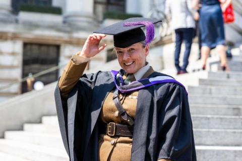 Army soldier in graduation gown and mortarboard