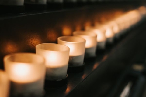 A row of small tealight candles, set up as a memorial