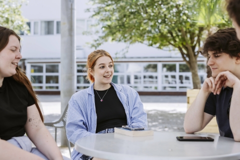 Students studying and talking outside on a table