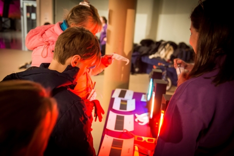 Image shows two guests from a previous Stargazing event doing a ‘spot the spectrum’ activity to work out what gas is in each lamp, in the same way that astronomers work out what stars are made of. 