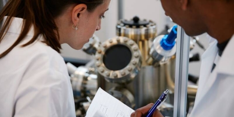 two people in a laboratory taking observations