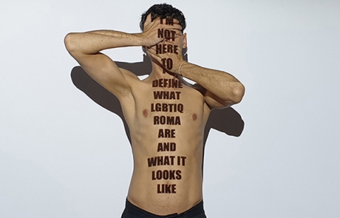 person covering his face, and the text 'I'm not here to define what lgbtiq roma are and what it looks like'