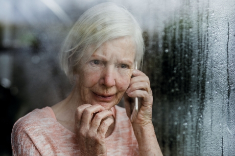 Elderly woman on the phone at a window