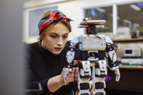 Female engineer working with robot