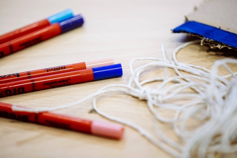 A collection of coloured pens and string on a table for an activity