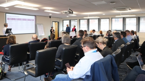 A staff member speaking to a room of people