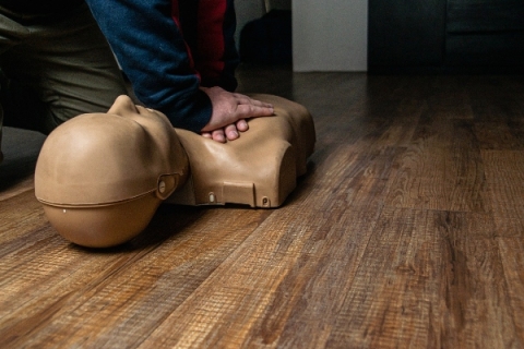 Person practicing CPR on a dummy