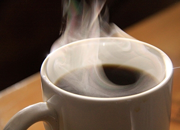 A steaming cup of black coffee