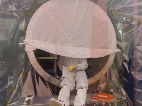 scientist inside a circular cavity dressed in hazmat suit