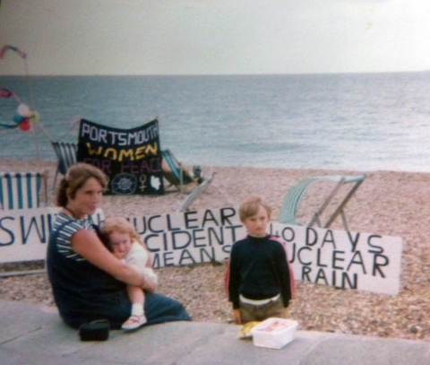 Picture of woman and children on beach in front of banners