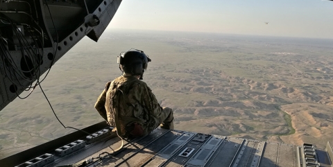 Soldier sits at open-backed helicopter in Persian Gulf