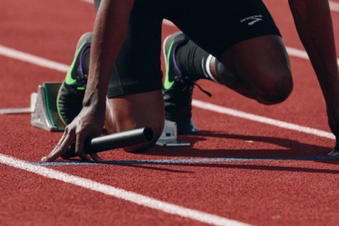 A close-up of a runners legs while they're on a starting block
