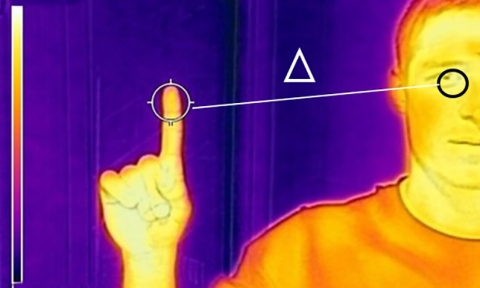 A thermal image of a person with their eye and index finger highlighted