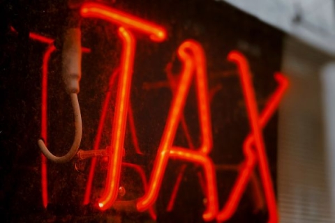 Red neon sign that reads TAX