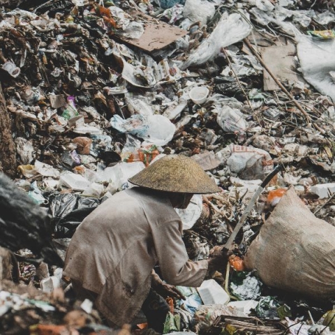 Person sifting through plastic waste - Photo by Fiqri Aziz Octavian on Unsplash