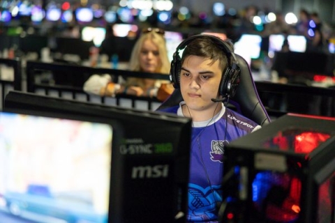 Student in purple top playing video game at esports Championship