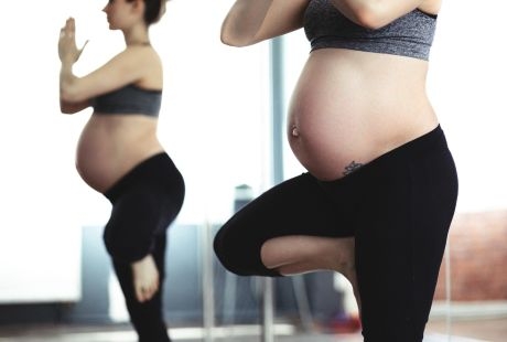 Two pregnant women doing yoga.