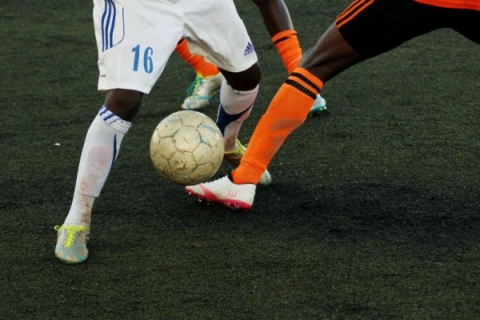 Image of two people's legs as they play football
