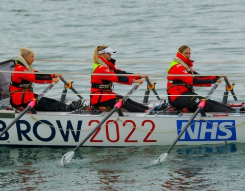 team of scientists rowing a rowboat for GB Row Race