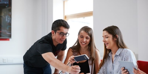 three students looking at a mobile phone