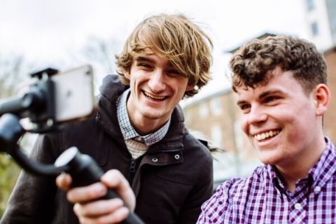 Journalist students holding phone on a gimbal and taking a picture