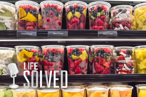 Plastic packaged fruit in yellow and red on shop shelves