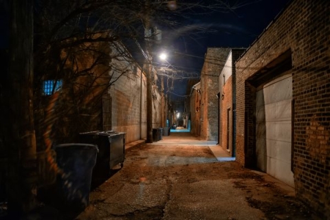 An alley at night, lit by a single street light
