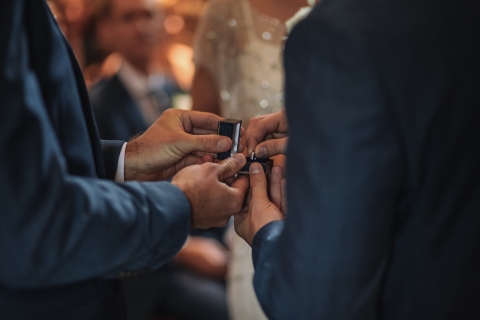 Picture of two men exchanging rings at their wedding.