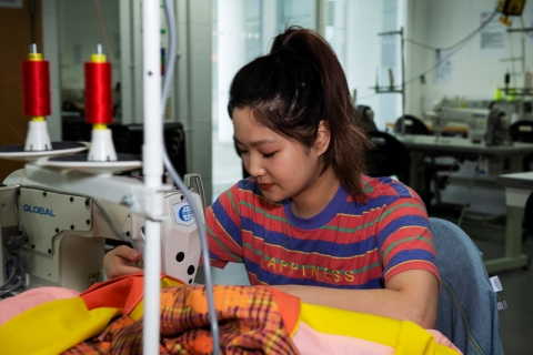 Venus Haochun Chen using sewing machine