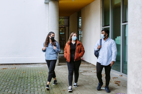 Students in masks walking on campus