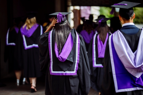 group of students walking in graduation dress