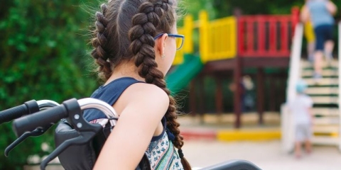 The back of a female with French plaits in a wheelchair