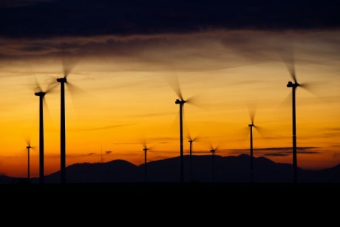 Several wind turbines against a sunset sky