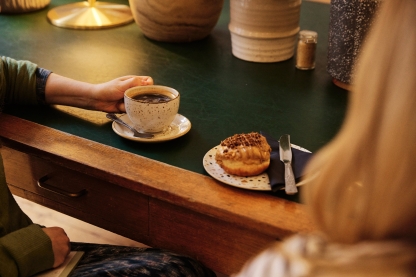 Two diners sitting with coffee and cake at tableHideout Coffee - City Guide 2022