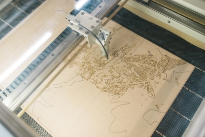 A laser cutter etching a design on wood