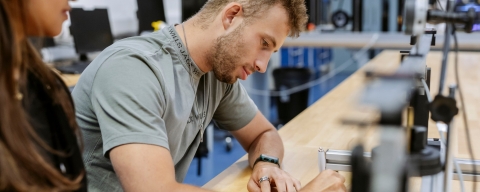 Students take measurements at a desk and record their results at Technology Facilities
