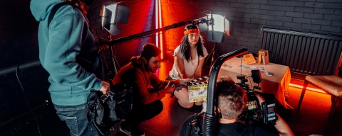 A film crew on set liaising with an actor