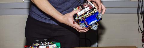 Electronic engineering student holding project