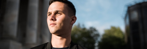 Student looking into distance standing outside the Guildhall