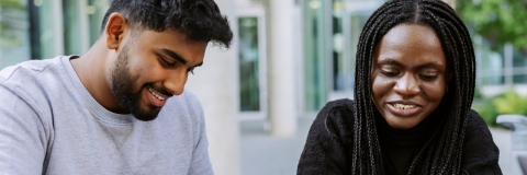 Two students working together from the same book in Eldon seating area