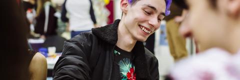 Student with purple hair smiles with friends at the feel good festival