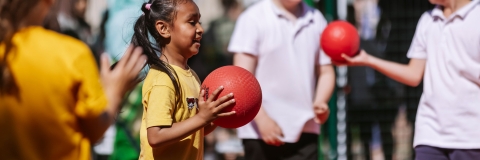 A little girl holding a basketball