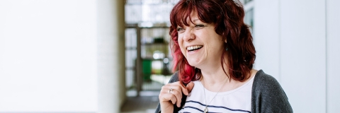 Headshot of woman with red hair stood outside of UoP building